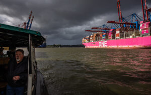Dunkle Wolken über dem sonnenbeschienenen ONE-Containerschiff